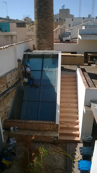 Trabajo vertical de limpieza de ventanales en el edificio Palma Activa