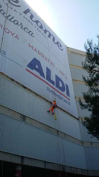 Fijación del cartel publicitario de ALDI en altura